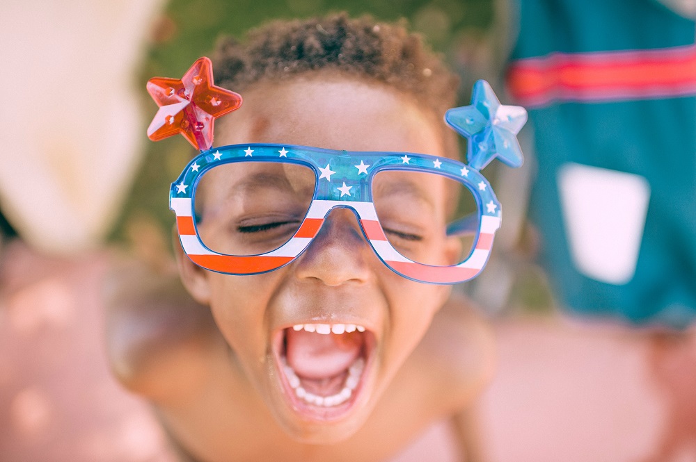 Young boy with technicolour glasses on Independence Day in New York