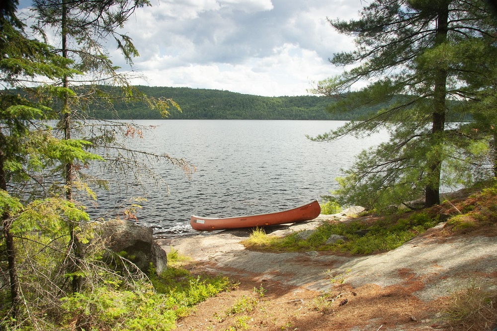 Canoe by lake in Algonquin Provincial Park, Ontario, Canada, exploring Eastern Canada